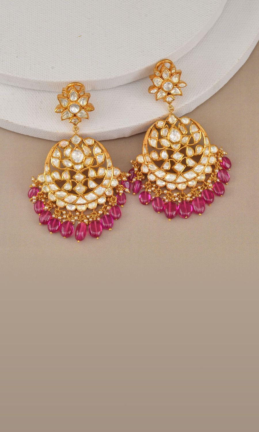 Gold kundan chandbali earrings with ruby drops on ivory linen